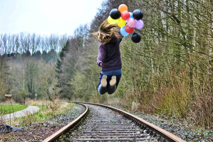 ballons girl jumping train rail forest fun