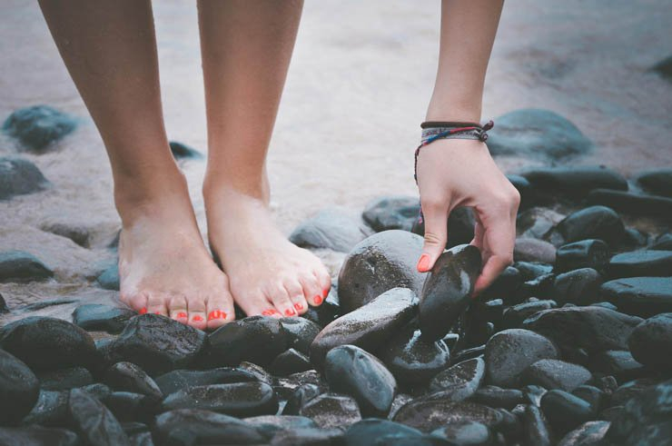 beach stones girl leg feet hand golding rock