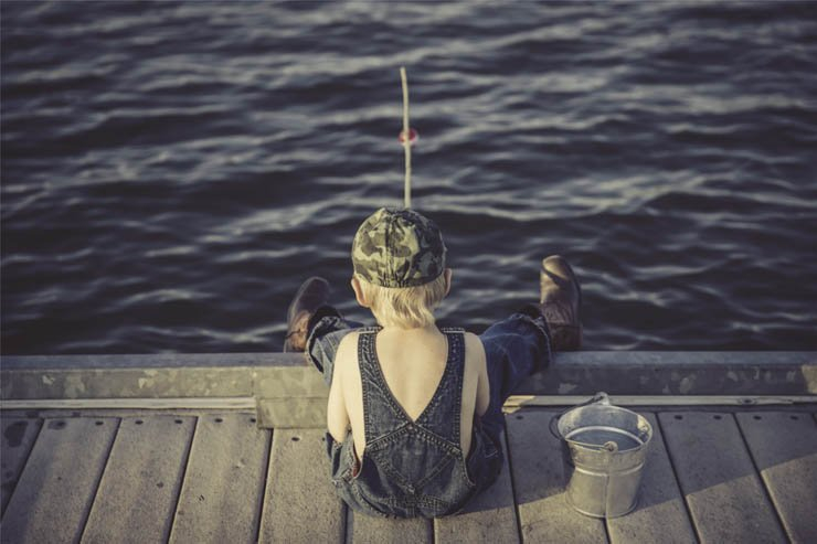 boy fishing back bucket fish jeans water sea river lake sunset