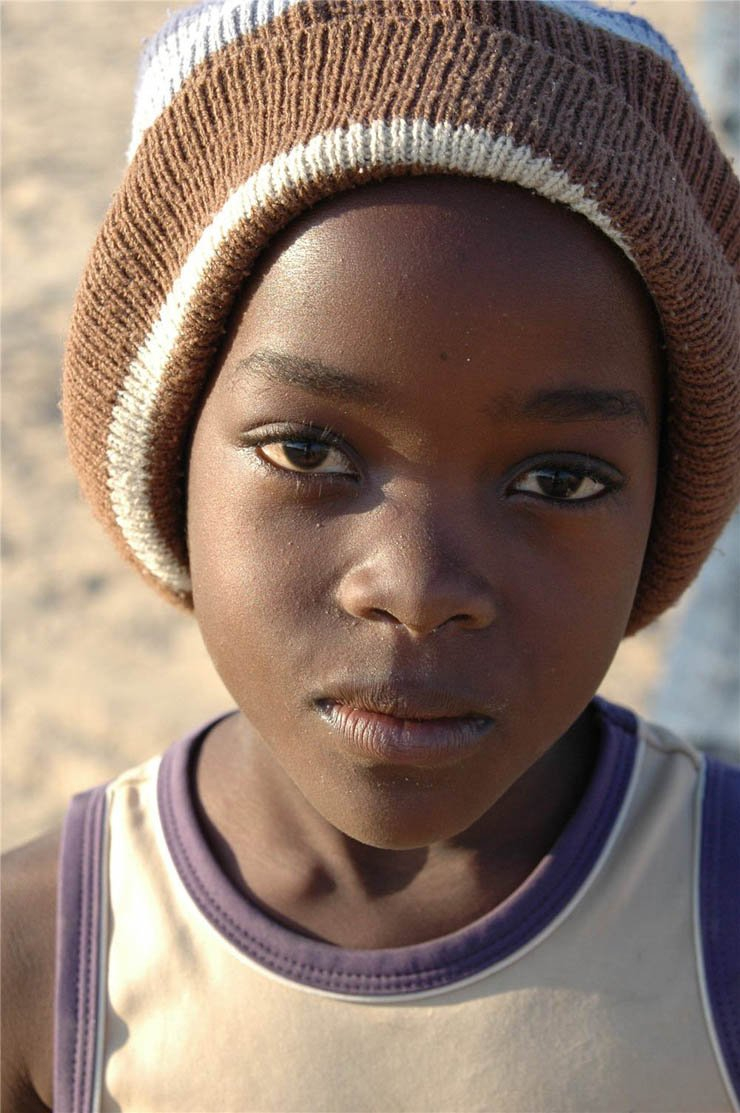 face faces africa african village kid kids boy hat cap