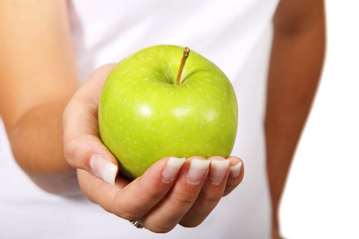 female holding hand green apple