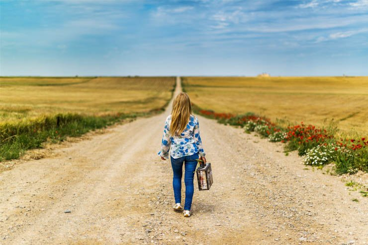 girl leaving alone walking luggage pathway fields