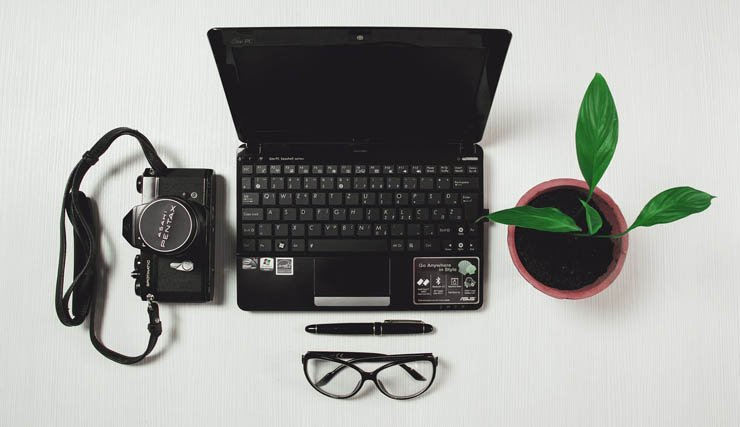 laptop computer camera photographer plant desk plants glasses pen business tech technology