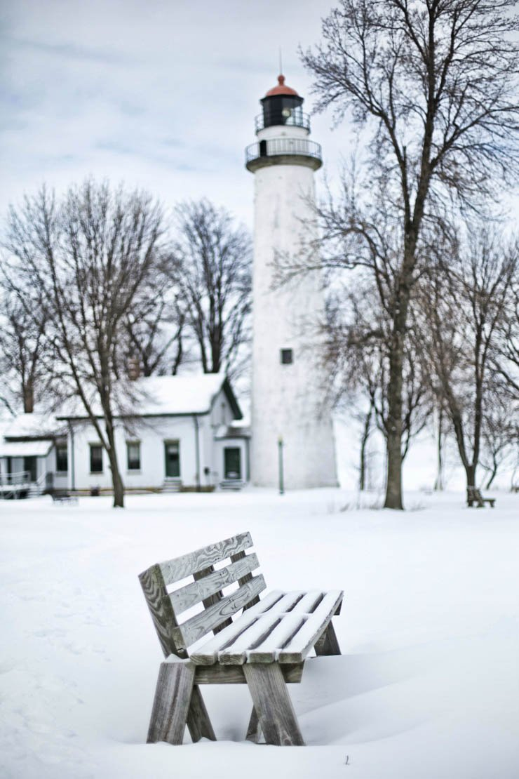 light house lighthouse water island ocean sea mountain sky snow snowy winter cold bench seat