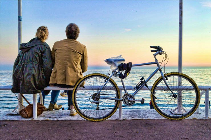 man woman lady sitting bike sea sky sunset water biking bicycle