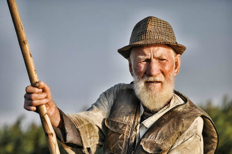 old man beard hat stick sky outdoor