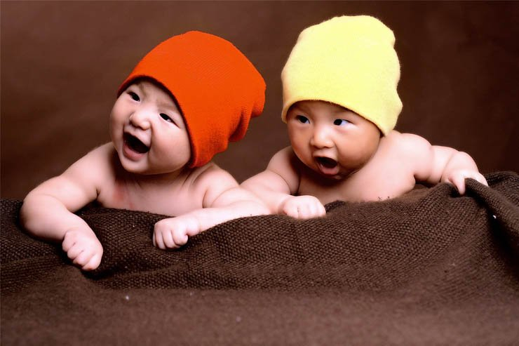 two little twin babies baby hats laughing happy