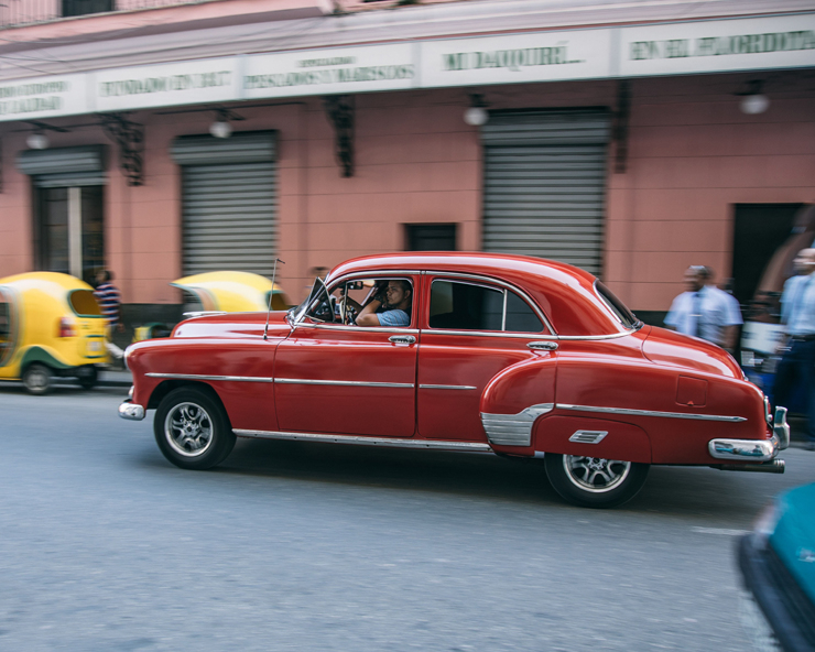 People Driving a Red Vintage Car