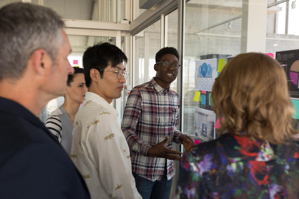 A small purpose-driven team in a workshop setting discussing brand values on a whiteboard